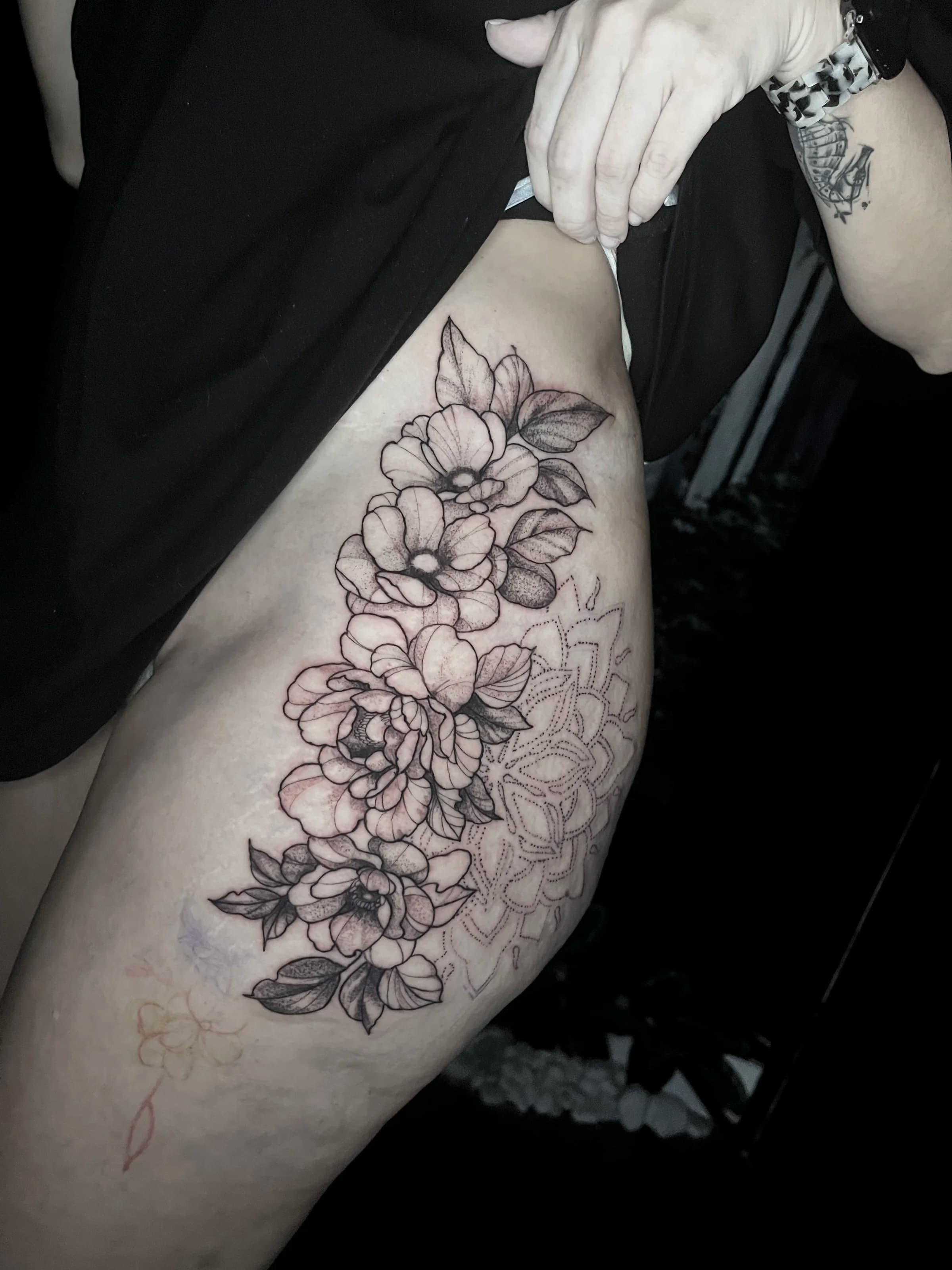 Tatuaje floral de línea fina en muslo